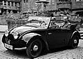 Ferry Porsche 1936 am Steuer des Volkswagen-Prototypen (V2) auf dem Marktplatz in Tübingen